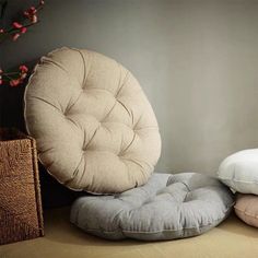 three round cushions sitting on top of each other in front of a vase with flowers