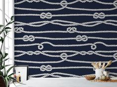 the wallpaper is decorated with white ropes and knots on navy blue background, along with a potted plant