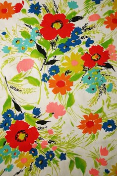 colorful flowers on white fabric with green leaves and red, orange, blue, yellow, pink