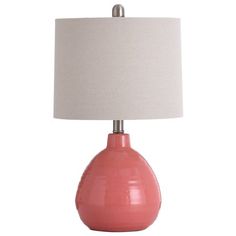 a pink ceramic table lamp with a white shade on the bottom and a silver base