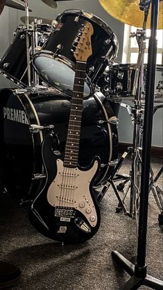 a black and white guitar sitting on top of a drum kit