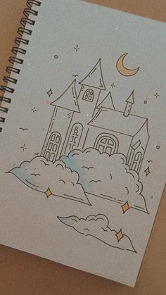 a notebook with a drawing of a castle on the cover and clouds in the foreground