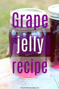 two jars filled with purple jelly sitting on top of a wooden table