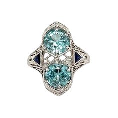 Simply Beautiful! Finely detailed Vintage Art Deco 2-Stone Blue Zircon Gold Cocktail Ring. Centering two securely nestled Blue Zircon, weighing approx. 5.00tcw, accented by synthetic Sapphires. Hand crafted 18K White Gold mounting. Ring size 5.5, we offer ring re-sizing. Ideal worn alone or as an alternative Engagement ring. The Ring is in excellent condition and was recently professionally cleaned and polished. More Beautiful in real time! Sure to be admired…illuminating your look with Timeless Beauty! Alternative Engagement Ring, Gold Cocktail Ring, Gold Cocktail, Gold Art Deco, Estilo Art Deco, Alternative Engagement Rings, Blue Zircon, Gold Art, Ring Vintage