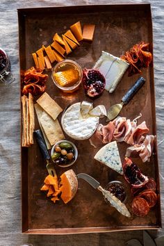 an assortment of cheeses and meats on a tray