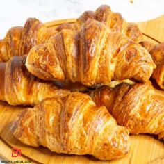 several croissants on a wooden platter ready to be eaten