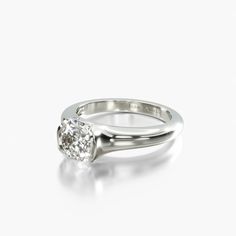 a white gold ring with a single diamond in the center, on a white background