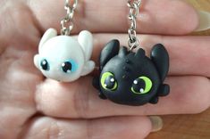 two small black and white key chains with green eyes