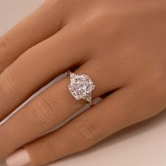 a woman's hand with a diamond ring on top of her finger and an engagement band