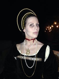 a woman dressed in costume with pearls on her head