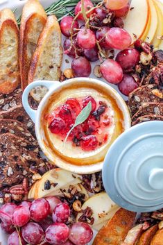 an assortment of breads, grapes and other food items