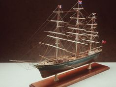 a model sailing ship on a wooden stand