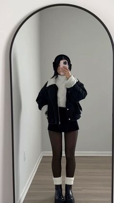 White top, black mini skirt, black bomber jacket, black tights, and cozy earmuffs is a winter staple outfit! #outfits#winter#winteroutfit#fashion#2024#trendy#aesthetic#oldmoneyaesthetic#djerf#simple#outfitidea#cozy#style Leavenworth Outfits, Warm But Cute Outfits, Aesthetic Winter Outfits Vintage, Cold Skirt Outfit, Men I Trust Concert Outfit, Black Flared Skirt Outfit, Rainboots Outfit Work, Taurus Venus Style Aesthetic, Winter Festival Outfit Outdoor Cold