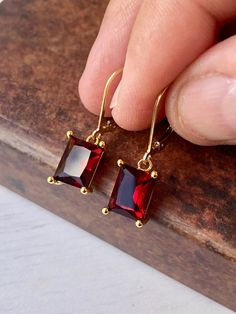 Garnet Earrings, January Birthstone, Dark Read Emerald Cut Earrings in Gold or Silver, Rectangular Baguette Drops, Garnet Jewelry for Women These elegant baguette earrings feature dark red rectangle gemstones prong set in your choice of gold filled or sterling silver. The vivid garnet emerald cut drops are suspended from lever back ear wires in the finish of your choice. These are great choice for simple yet elegant earrings to wear virtually anywhere. Ideal gift for a woman born in January, as Red Gemstone Earrings, Simple Earrings Gold, Precious Stones Jewelry, Emerald Cut Earrings, Red Garnet Jewelry, Baguette Earrings, Red Rectangle, Silver Gift Wrap, Cut Earrings