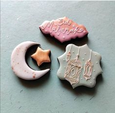 three decorated cookies sitting on top of a table next to each other, one with a star and the other with a crescent