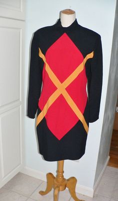 Lovely color block dress by Nicole Miller made during the 1980's. This is a crepe most likely rayon as it has a dry clean only tag. The dress is black with a large red diamond with a large orange x in the center. . The back is plain black. It has a stand up collar with long sleeves and padded shoulders and back hidden zipper. It is fully lined. Label Nicole Miller size 12 Dry Clean only. Measurements - bust 38 waist 32 hips 40 length 35 and sleeve 23.5 inches. It is in excellent vintage conditio Noir Uni, Color Block Dress, Feather Headband, Colour Blocking, Stand Up Collar, Block Dress, Red Diamond, Colorblock Dress, Crepe Dress