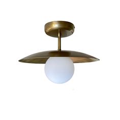 a brass ceiling light with a white ball hanging from it