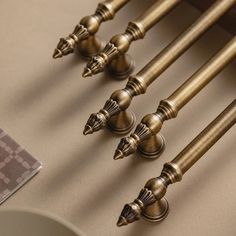 four antique style brass finials on the side of a table