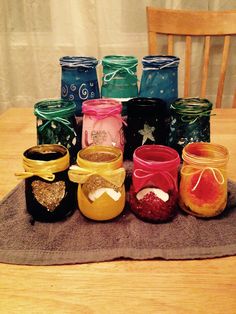 there are many jars on the table that have different colors and designs, but one is empty