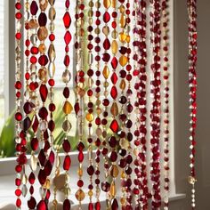 red and gold beaded curtains hanging in front of a window