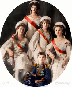 a group of women in white dresses posing for a photo with a boy sitting on the floor