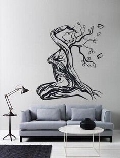 a living room with a couch and tree wall decal