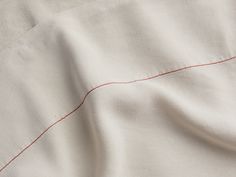 the red line is stitched into the white fabric