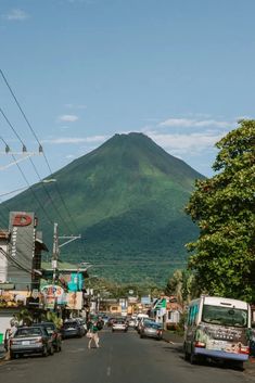 cars are parked on the street in front of a mountain