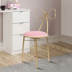 a pink chair sitting in front of a white desk