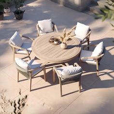 an outdoor table with white cushions and chairs