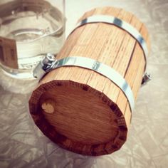 a wooden barrel sitting next to a glass filled with water