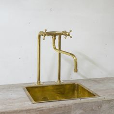 an old fashioned brass sink with two faucets