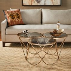 a living room with a couch, coffee table and painting on the wall behind it