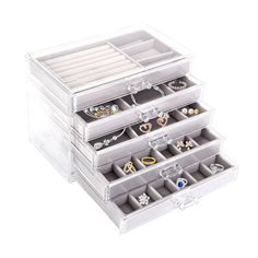 three clear drawers with rings and jewelry in them