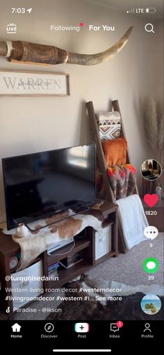 a flat screen tv sitting on top of a wooden entertainment center in a living room