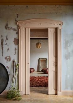 an open door leading to a bedroom with a bed in the corner and mirror on the wall