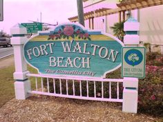 the sign for fort walton beach is painted pink and blue