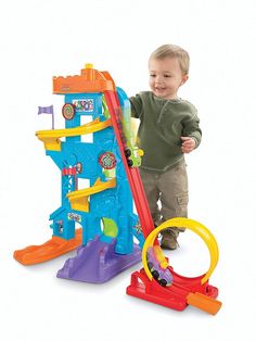 a little boy standing next to a toy set