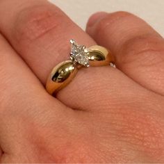 a woman's hand with a gold and diamond ring