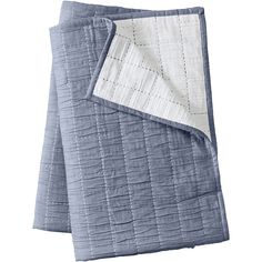 the blue and white quilted blanket is folded up