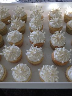 cupcakes with white frosting are arranged on a tray