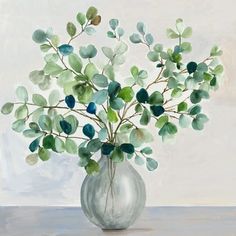 a vase filled with green leaves on top of a table