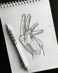 a pencil drawing of a hand holding the middle finger with two fingers on it, in front of a notepad