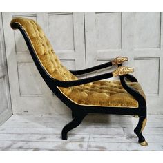 a gold and black chair sitting on top of a white floor next to a wall