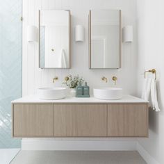 two white sinks sitting under mirrors in a bathroom