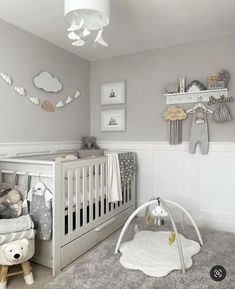 a baby's room with grey walls and white furniture