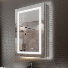 a bathroom sink with a lighted mirror above it