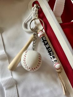 a baseball and bat keychain sitting on top of a white shirt