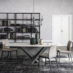 a dining room table with chairs and bookshelf in the backround area