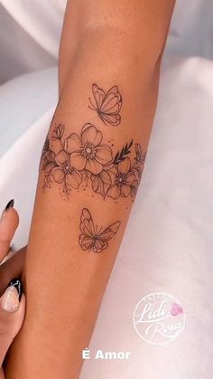 a woman's arm with flowers and butterflies on it